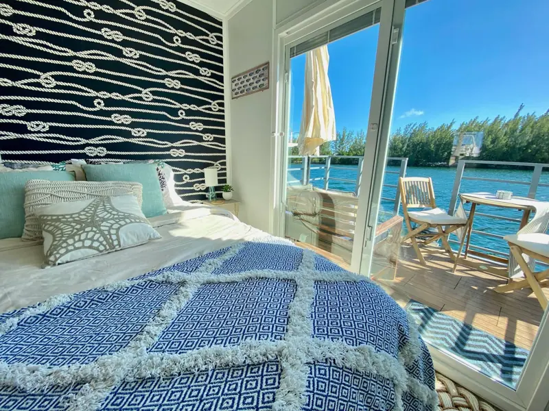 Queen bed facing sliding glass doors that open onto the water at Casa Azul houseboat